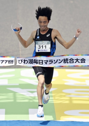 Gaku Hoshi crosses the finish line to win the combined Osaka Marathon and Lake Biwa Mainichi Marathon in Osaka on Sunday. | KYODO