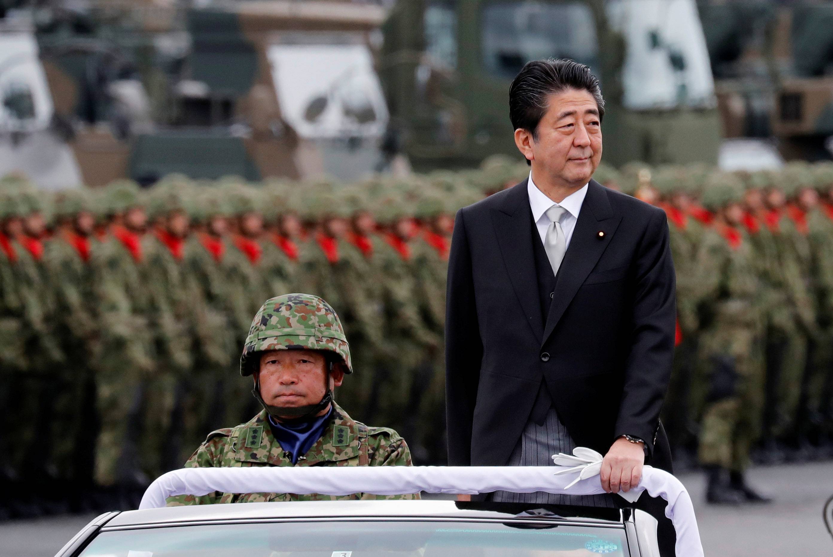 Then-Prime Minister Shinzo Abe reviews Self-Defence Forces troops during an annual ceremony at Camp Asaka, which straddles Tokyo and Saitama prefectures, in October 2018.   | REUTERS