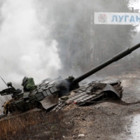 Smoke rises from a Russian tank destroyed by the Ukrainian forces on the side of a road in Ukraine\'s Luhansk region on Saturday. | AFP-JIJI