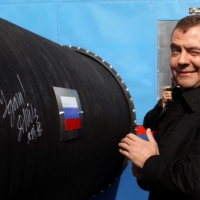 Former Russian President Dmitry Medvedev gestures after writing \'Good Luck!\' on a pipe of the Nord Stream pipeline near the Russian town of Vyborg in April 2010. | REUTERS