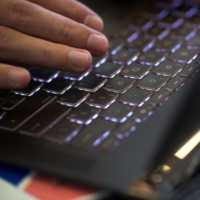 An attendee uses a laptop with a cyrillic keyboard at Moscow\'s CrytoSpace conference in December 2017. One of the world’s most successful ransomware groups is reeling from a massive release of its own internal data after the cybercriminal gang aligned itself with the Russian government. | BLOOMBERG