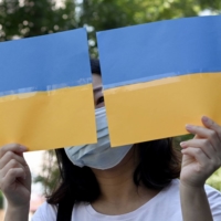 A woman holds a placard during a protest against Russia\'s invasion of Ukraine on Tuesday. | AFP-JIJI