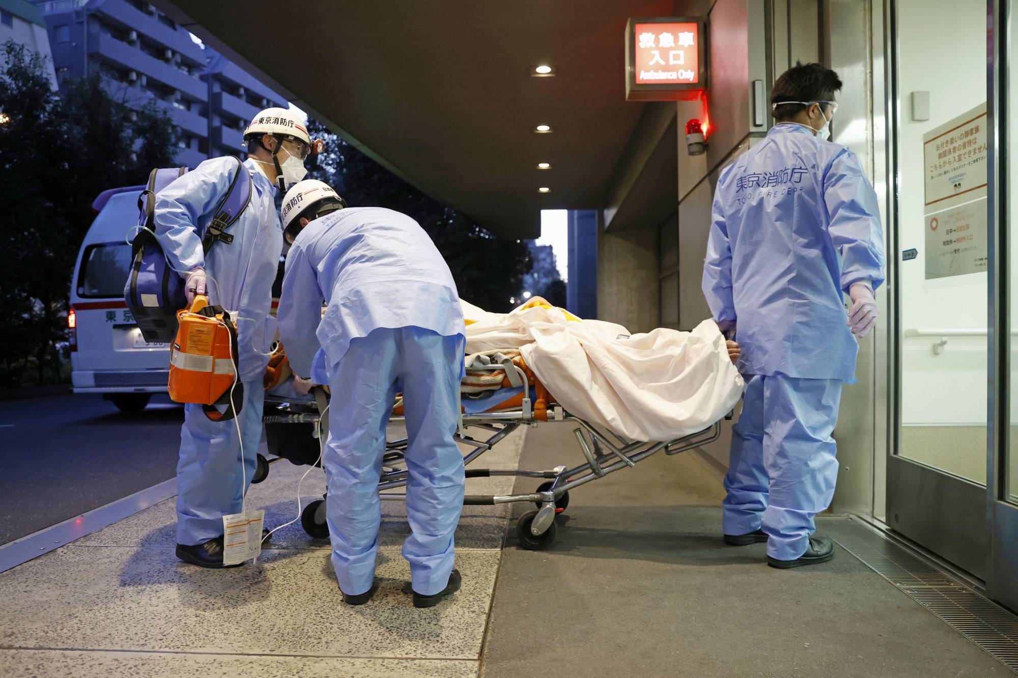 An ambulance crew brings a patient into a hospital in Tokyo's Shinjuku Ward on Feb. 1. | KYODO