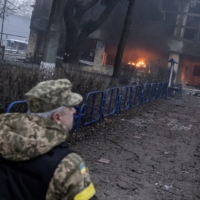 A member of the Ukrainian military walks near a building after a blast, amid Russia\'s invasion in Kyiv on Tuesday. | REUTERS