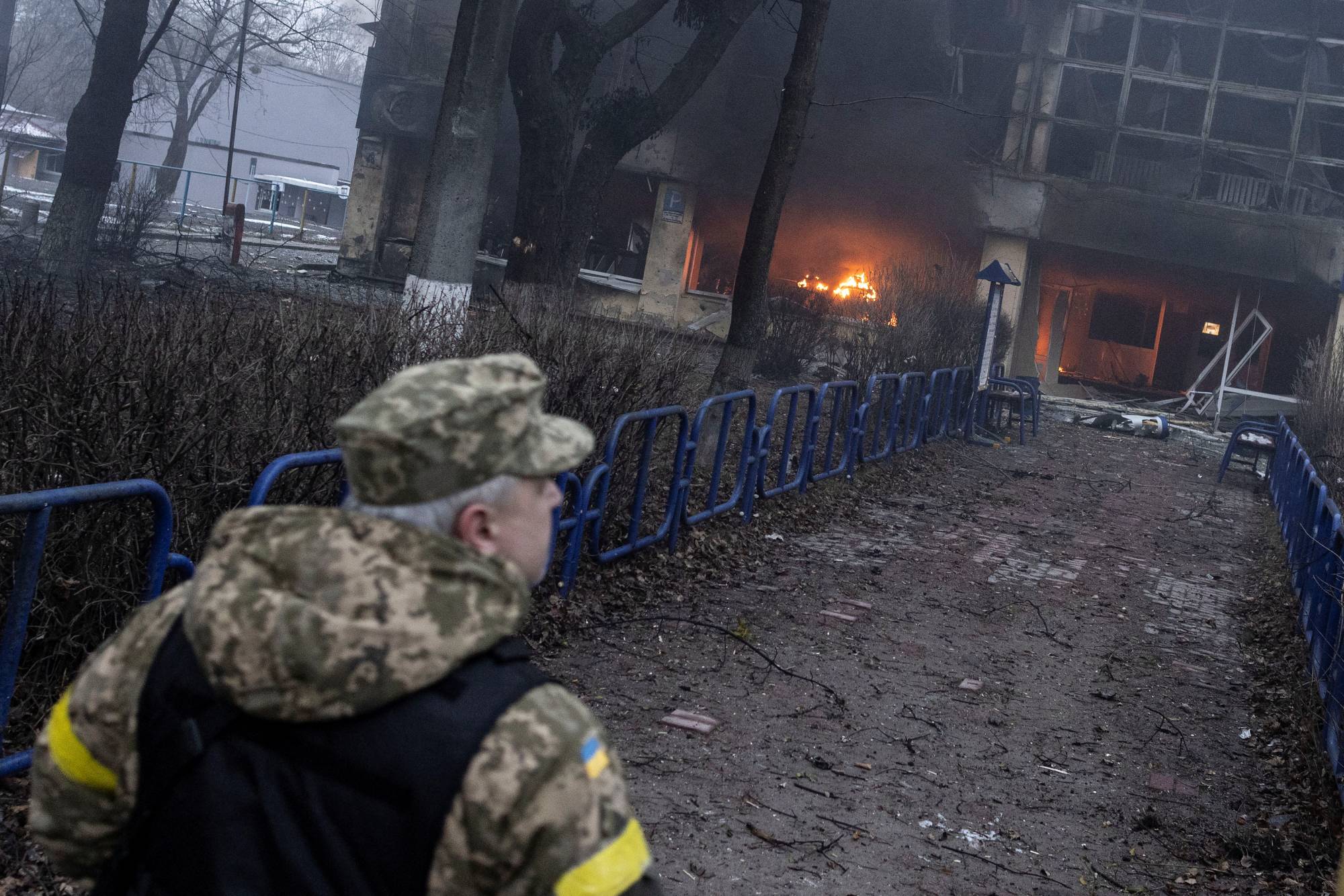 A member of the Ukrainian military walks near a building after a blast, amid Russia's invasion in Kyiv on Tuesday. | REUTERS