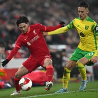 Liverpool\'s Takumi Minamino (left) and Norwich City\'s Dimitris Giannoulis vie for the ball during their F.A. Cup match in Liverpool, England, on Wednesday. | AFP-JIJI