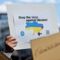 A protester holds up a placard during a rally denouncing Russia over its actions in Ukraine, near the Russian Embassy in Tokyo on Feb. 23. Moscow\'s invasion of Ukraine has caused anxiety among Russians living in Japan. | REUTERS
