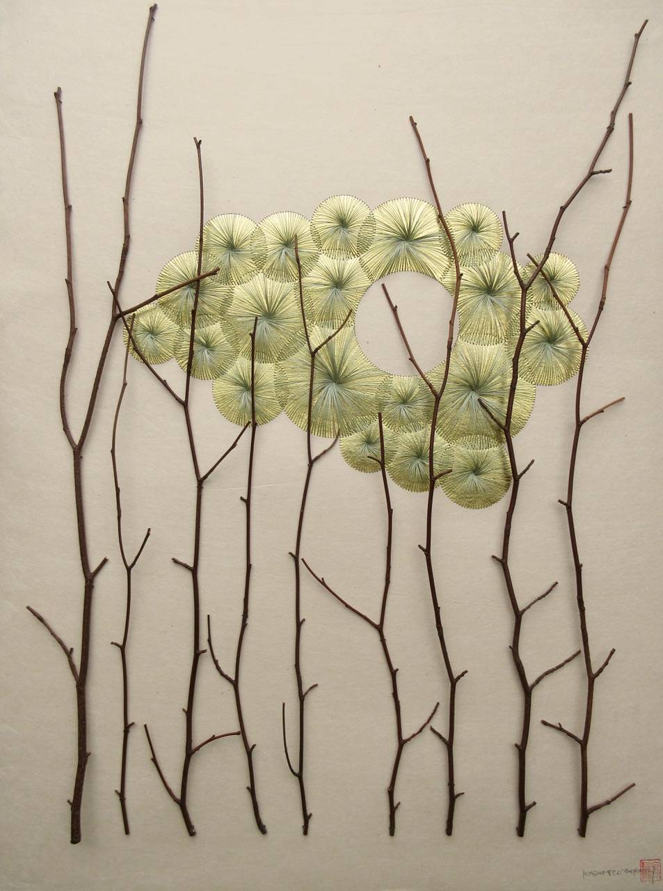 Artist Kazuhito Takadoi's 'Yuhi' ('Setting Sun') is constructed from grass, hand-sewn over gold leaf, set behind hawthorn twigs, all harvested by the artist. | JAGGEDART