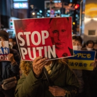 People hold up placards as they take part in a protest against Russia\'s invasion of Ukraine during a rally near the Russian Embassy in Tokyo on Friday.  | AFP-JIJI
