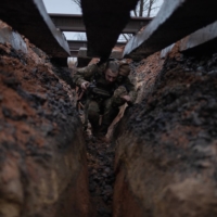 A Ukrainian Marine moves along a trench below railroad tracks in Verkhnotoretske, Ukraine, on Feb. 8. | TYLER HICKS / THE NEW YORK TIMES