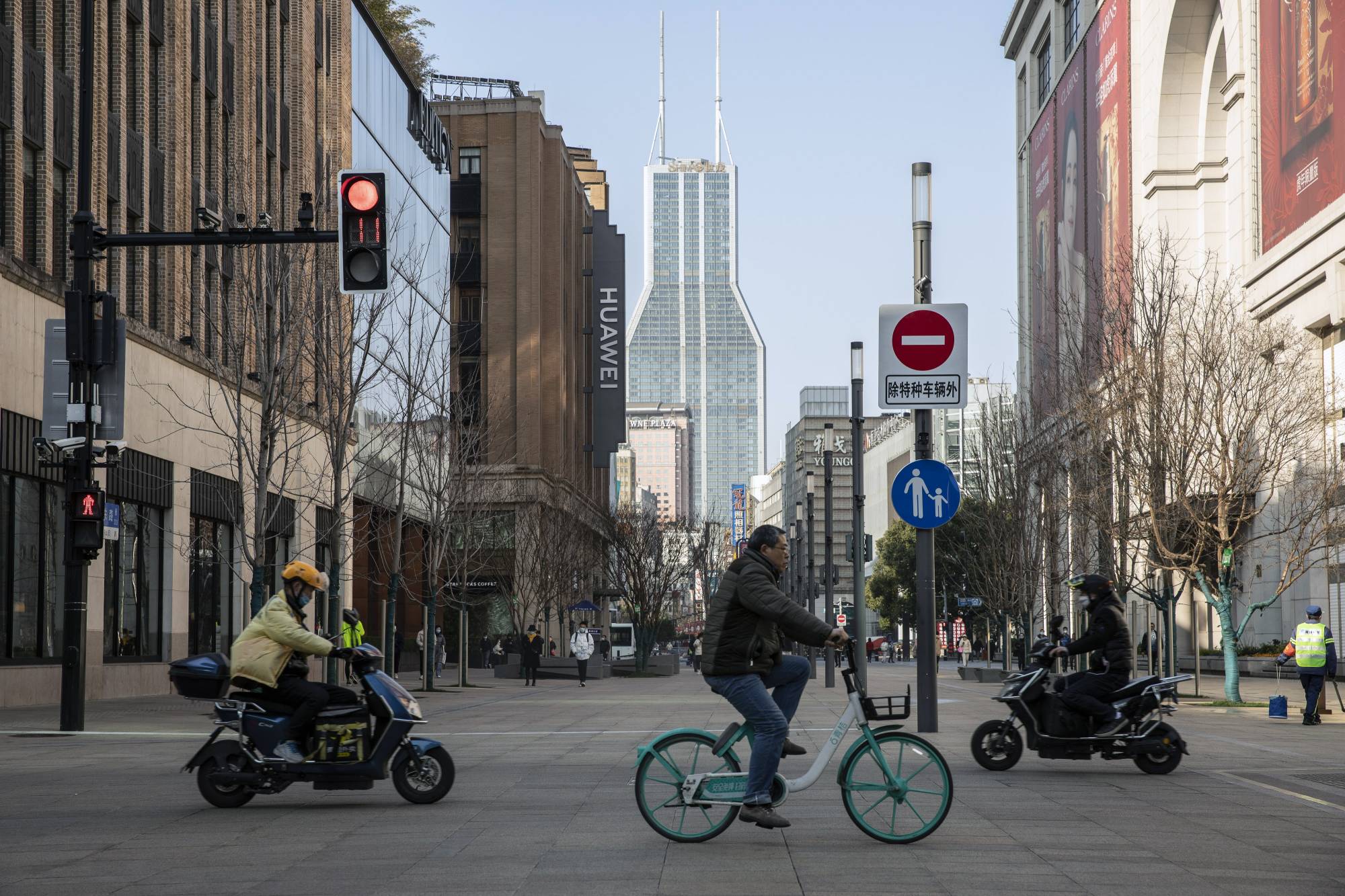 Cyclists and motorcyclists rides along Nanjing road in Shanghai on Feb. 27. China's Politburo vowed to strengthen macroeconomic policies to stabilize the economy this year, suggesting more support could be on the cards to boost growth ahead of a key leadership meeting later this year. | Bloomberg