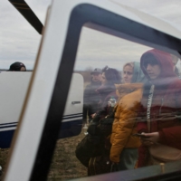 People fleeing the Russian invasion of Ukraine look on as they board a Humanitarian Aid helicopter going to Prague, Czech Republic, at a border crossing in Vysne Nemecke, Slovakia, on Saturday. | REUTERS
