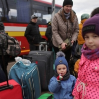 People fleeing the Russian invasion of Ukraine wait for transport after arriving in Slovakia, at a border crossing in Vysne Nemecke, Slovakia, on Saturday. | REUTERS