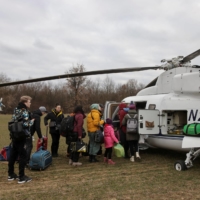 People fleeing the Russian invasion of Ukraine board a Humanitarian Aid helicopter going to Prague, Czech Republic, at a border crossing in Vysne Nemecke, Slovakia, on Saturday. | REUTERS