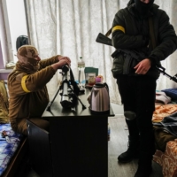 A Ukrainian sniper cares for his American-donated rifle in Kyiv on Saturday. Soldiers from both sides presented some of the few firsthand accounts of the fighting that have emerged in the 10-day war, though from very different perspectives.  | LYNSEY ADDARIO/THE NEW YORK TIMES