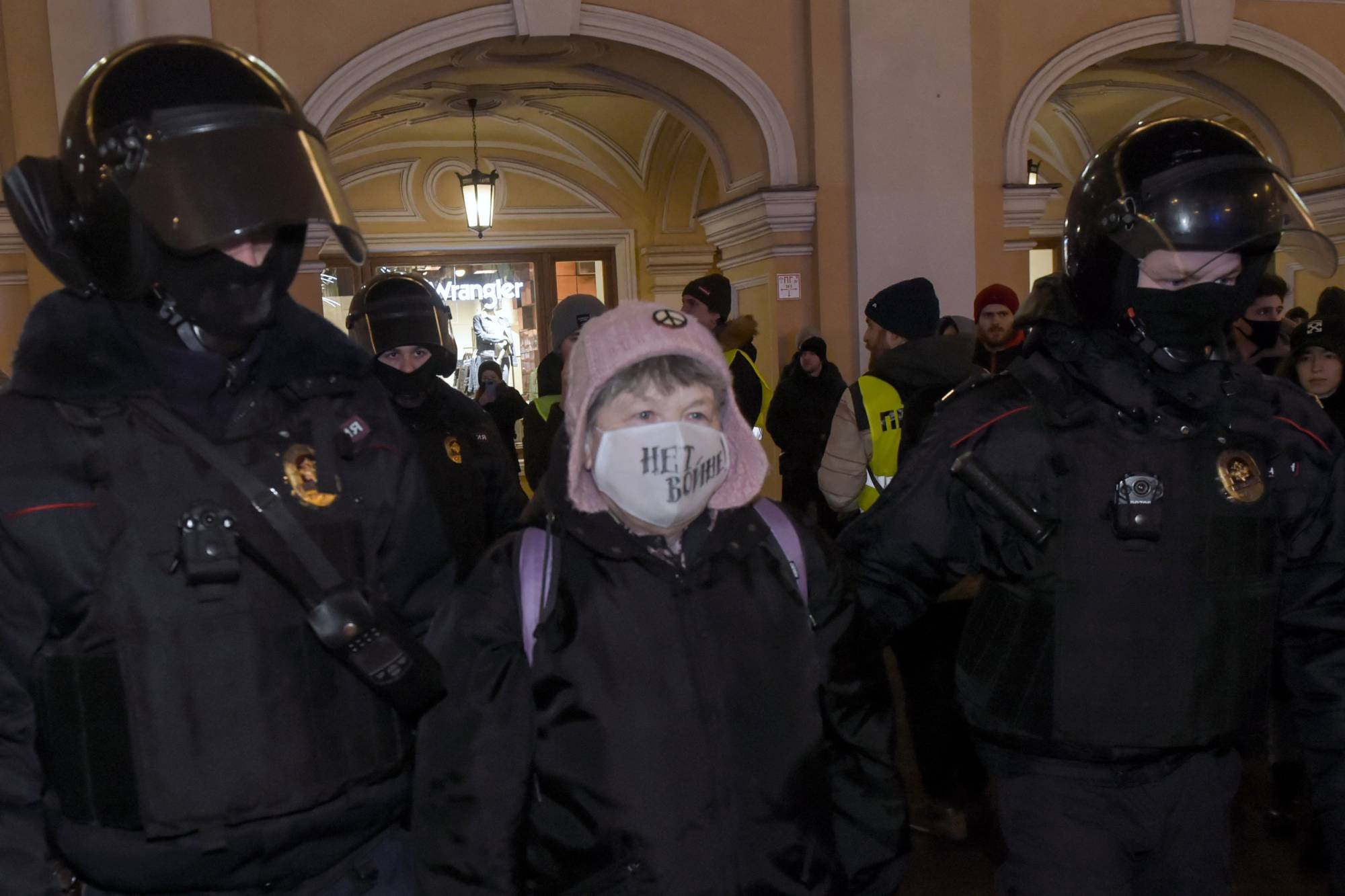 Police officers detain a demonstrator wearing a protective mask carrying a message that reads 'No war' during a protest against Russia's invasion of Ukraine in central St. Petersburg on Thursday. | AFP-JIJI