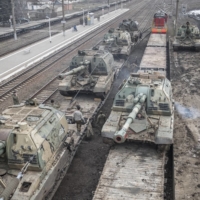 Russian howitzers are loaded onto train cars at a station outside Taganrog, Russia, in February, 2022. | THE NEW YORK TIMES