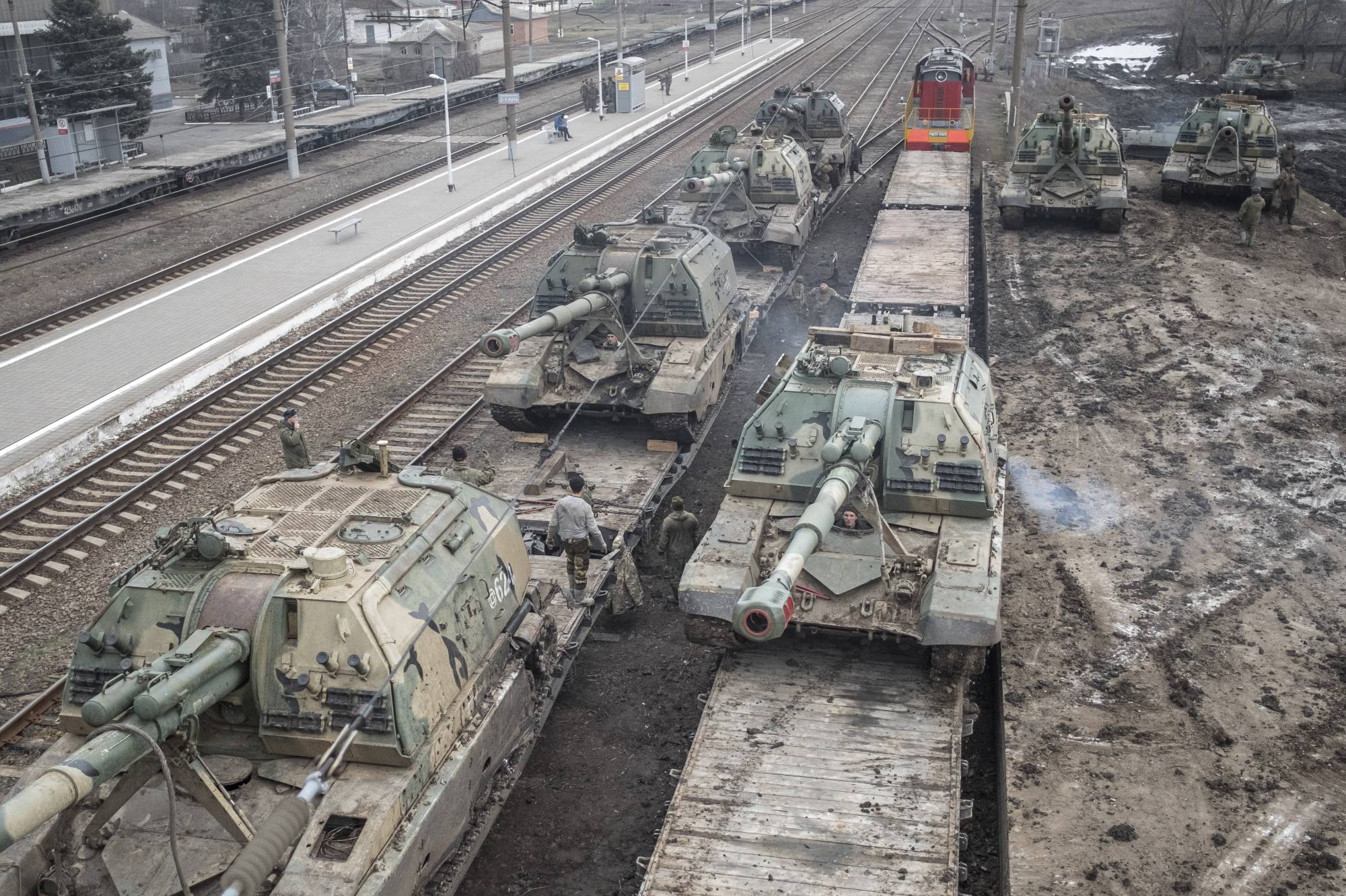Russian howitzers are loaded onto train cars at a station outside Taganrog, Russia, in February, 2022. | The New York Times