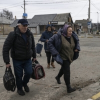 Civilians flee the village of Irpin, near Kyiv, on Sunday. | LYNSEY ADDARIO/THE NEW YORK TIMES