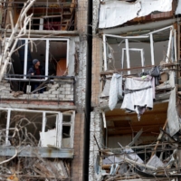 A resident surveys damage to an apartment building in Kramatorsk, Ukraine, on Monday. | AFP-JIJI