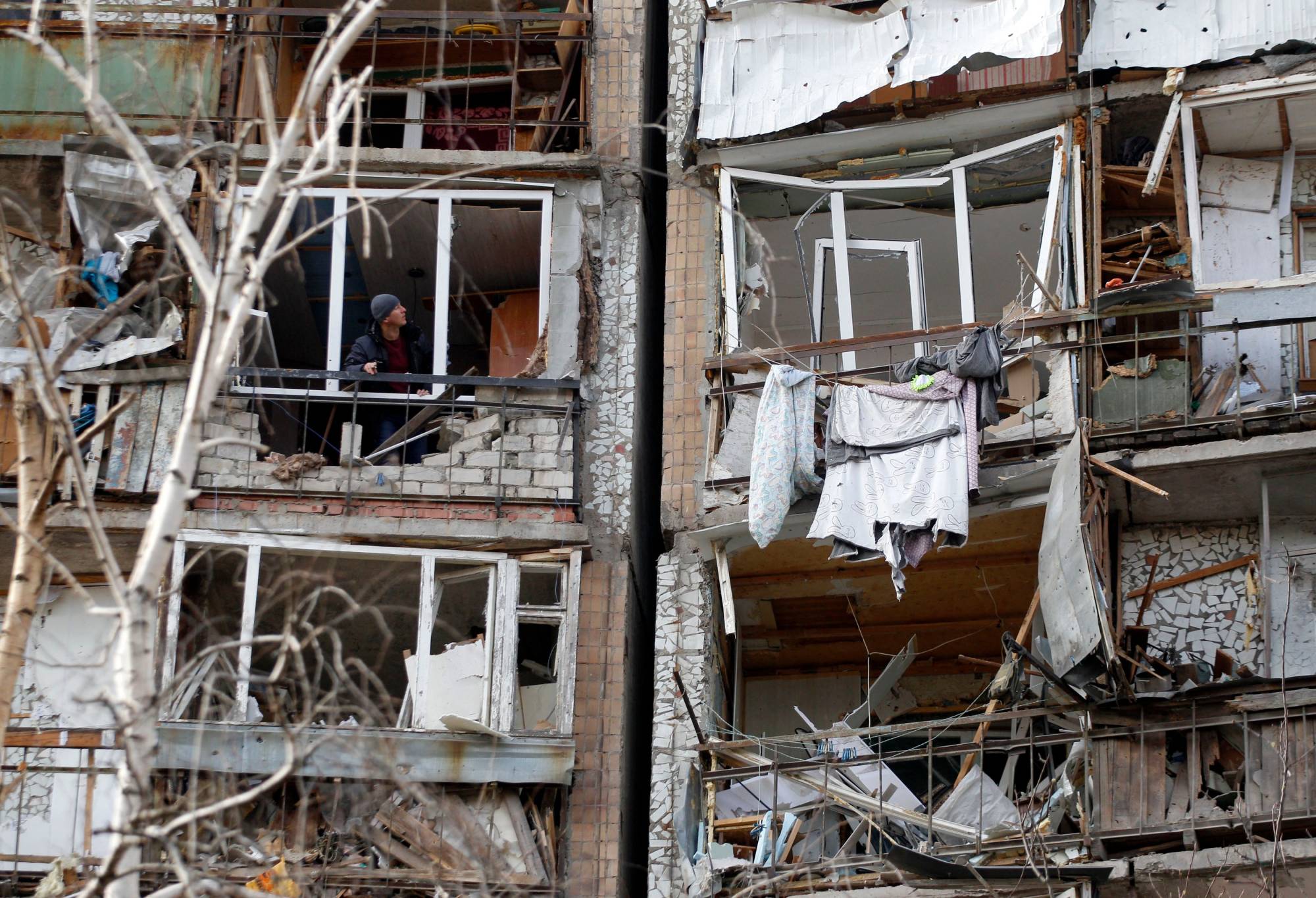 A resident surveys damage to an apartment building in Kramatorsk, Ukraine, on Monday. | AFP-JIJI