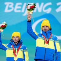 Ukrainian gold medalist Oksana Shyshkova (left) and guide Andriy Marchenko pose during the medal ceremony for the women\'s long distance classical technique vision impaired event in Zhangjiakou, China, on Monday. | OLYMPIC INFORMATION SERVICES / VIA REUTERS
