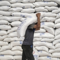A worker carries a sack of rice inside a National Food Authority warehouse in Valenzuela, Metro Manila, in 2020. | BLOOMBERG