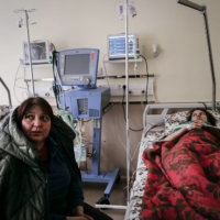 Myroslava Svystovych sits with her wounded daughter, Lada, who was shot in Irpin, Ukraine.  | LYNSEY ADDARIO/THE NEW YORK TIMES