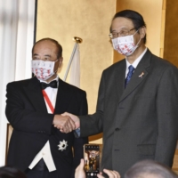 Wang Jin-pyng (left) and Hiroyasu Izumi shake hands in Taipei on Wednesday. | KYODO