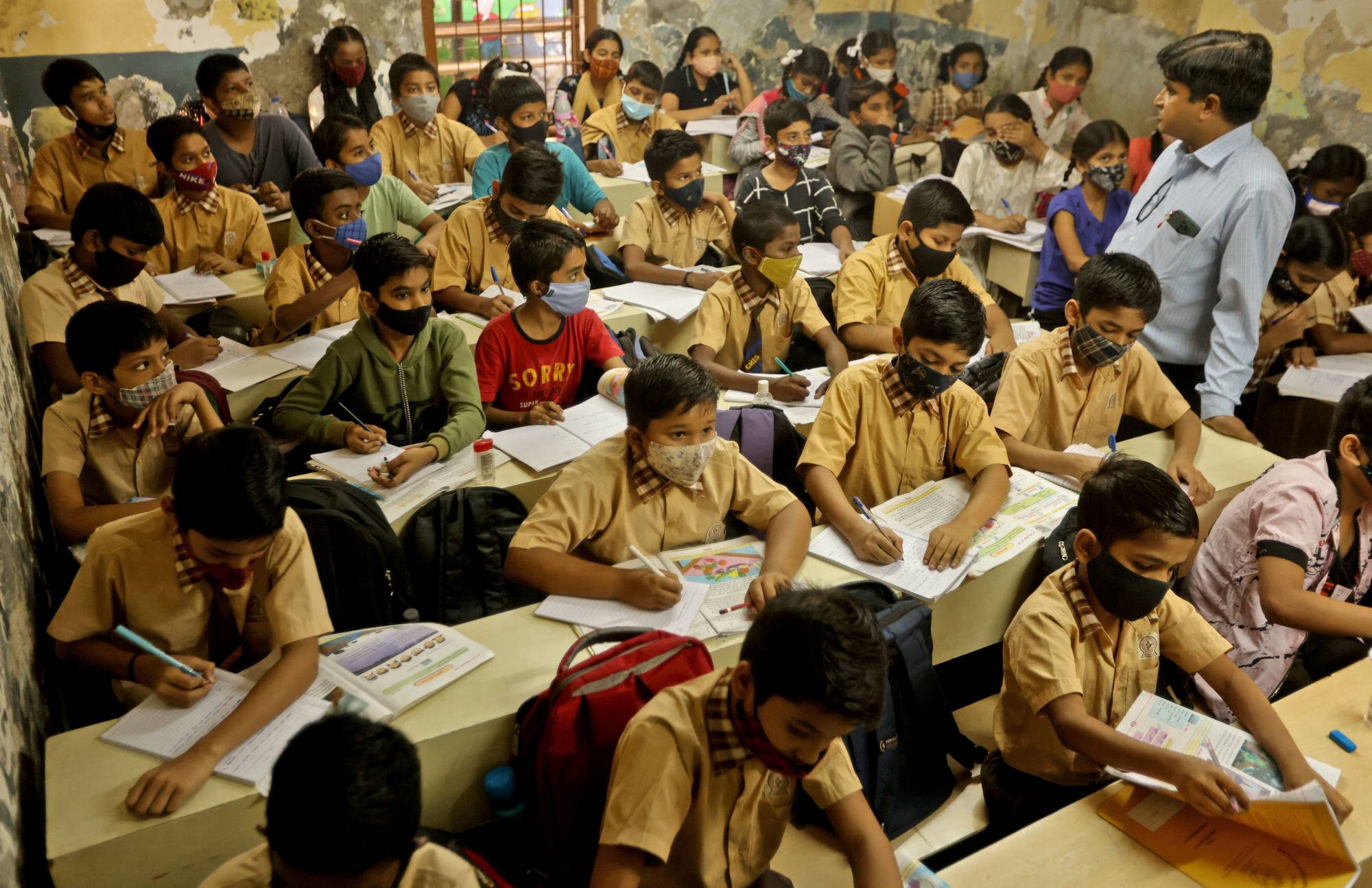 Children in Mumbai attend classes on Feb. 24 after long bouts of school closures due to the pandemic.  | REUTERS