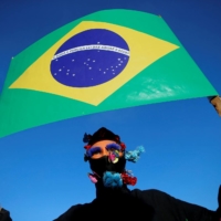 A demonstrator takes part in the Act for the Earth protest, speaking out against Brazil\'s President Jair Bolsonaro\'s environmental policies that contribute to deforestation and mining on Indigenous lands, in Brasilia on Wednesday. | REUTERS