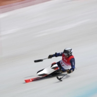 Taiki Morii of Japan speeds down the slopes during the Para Alpine Skiing event at the Beijing 2022 Winter Paralympic Games on Thursday. | REUTERS