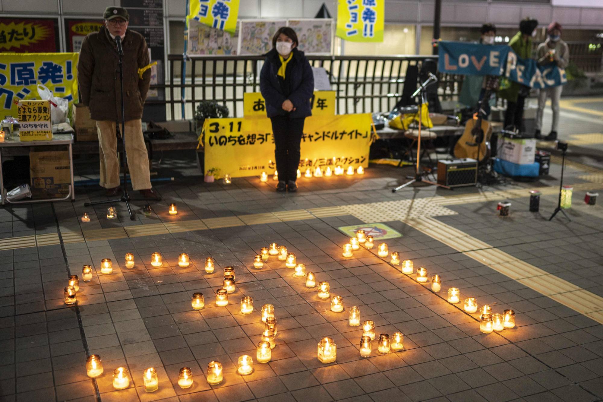 People take part in a candle vigil in memory of 2011 earthquake and tsunami victims in Mitaka, western Tokyo, on Friday.  | AFP-JIJI