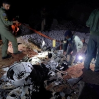 People work around what Pakistani security sources say is the remains of a missile fired into Pakistan from India, near Mian Channu, Pakistan, on Wednesday.   | PAKISTANI SECURITY SOURCES / VIA REUTERS