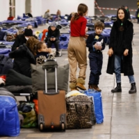 Refugees are seen at the new center for refugees arriving from Ukraine at the Messe in Berlin on Friday.  | AFP-JIJI