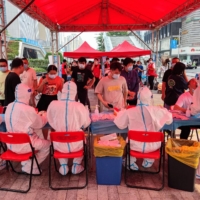 People receive COVID-19 tests in Shenzhen in June. The southern Chinese tech hub was put under a citywide lockdown on Sunday after it reported 66 new coronavirus cases. | AFP-JIJI
