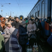Refugees who fled Ukraine wait to get their passports stamped before boarding a train to Budapest in Zahony, a border town in eastern Hungary, on Friday. | MAURICIO LIMA / THE NEW YORK TIMES
