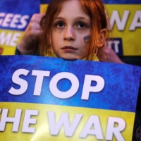A girl holds a sign at a demonstration against the Russian military\'s invasion into Ukraine, calling on President Vladimir Putin to stop the war, in Tel Aviv on Saturday. | REUTERS