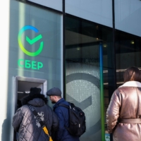 Customers use an ATM outside a Sberbank branch in Moscow on Feb. 28.  | BLOOMBERG
