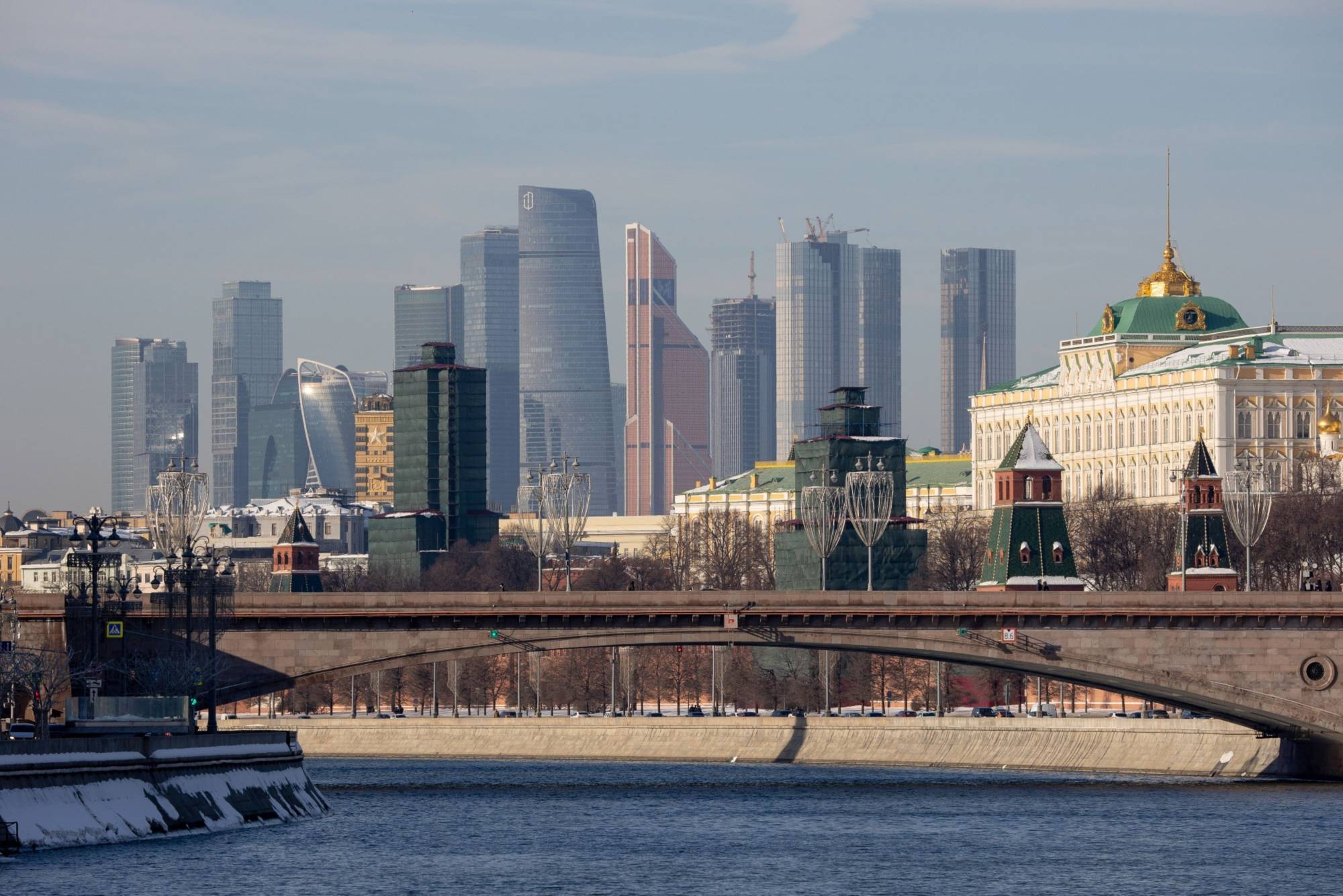 Skyscraper office buildings loom over the Moscow International Business Center (MIBC), also known as Moscow City, and the Grand Kremlin palace, right, as viewed from the River Moskva in Moscow on Feb. 15.  | BLOOMBERG