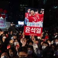 Supporters of Yoon Suk-yeol rally outside the People Power Party headquarters in Seoulon, South Korea, on Wednesday. The former top prosecutor won election as South Korea’s president, returning the conservative opposition to power after five years in the wilderness. | BLOOMBERG