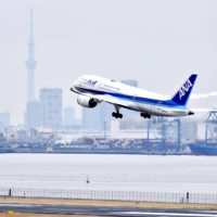 Japan is considering raising the daily cap on overseas arrivals to 10,000 from the current 7,000 starting in April. | KYODO