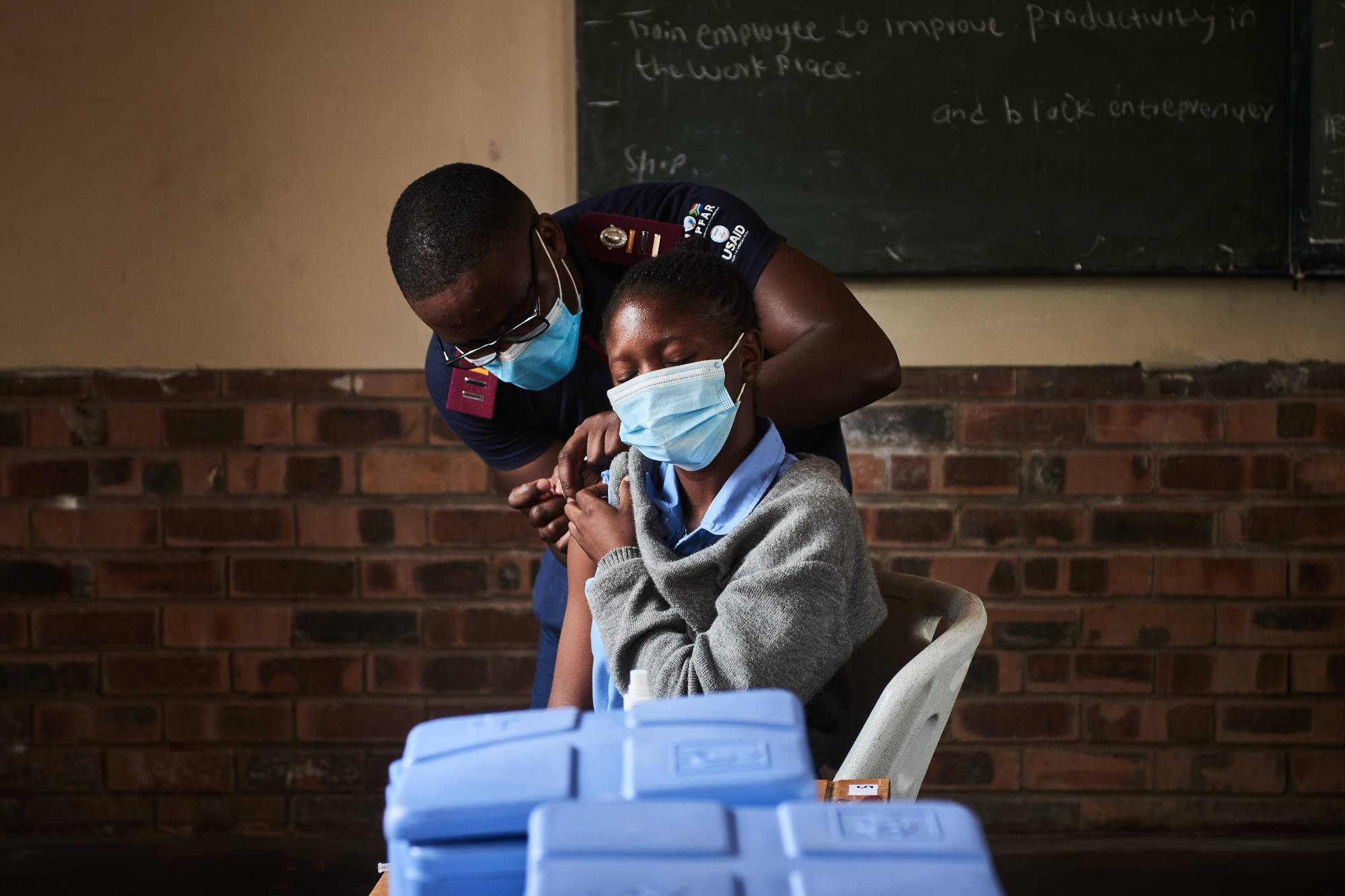 A health worker administers a COVID-19 vaccine during a rural vaccination drive in Mpumalanga, South Africa, on March 9. A  tentative World Trade Organization deal on COVID-19 vaccine intellectual property comes after months of negotiations over how to accelerate vaccine production in developing countries, where vaccination rates have lagged far behind those of wealthy countries. | BLOOMBERG
