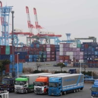 Trucks and containers at a shipping terminal in Yokohama in February. Japan reported a wider-than-expected trade deficit in February as an energy-driven surge in imports outstripped growth in exports. | BLOOMBERG