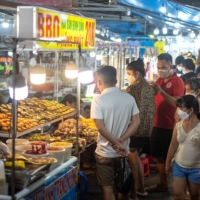 Visitors gather at a night market on Phu Quoc Island in Vietnam, on Feb. 26. Vietnam announced that it would open its borders on March 15 to international tourists, with a one-day hotel isolation. | LINH PHAM / THE NEW YORK TIMES

