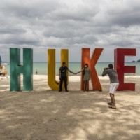 Visitors pose for photos on Phuket Island in Thailand, on Feb. 27. To visit Phuket Island, international tourists need to submit a “Thailand Pass,” which requires uploading vaccination records, hotel reservations and proof of health insurance. | ADAM DEAN / THE NEW YORK TIMES