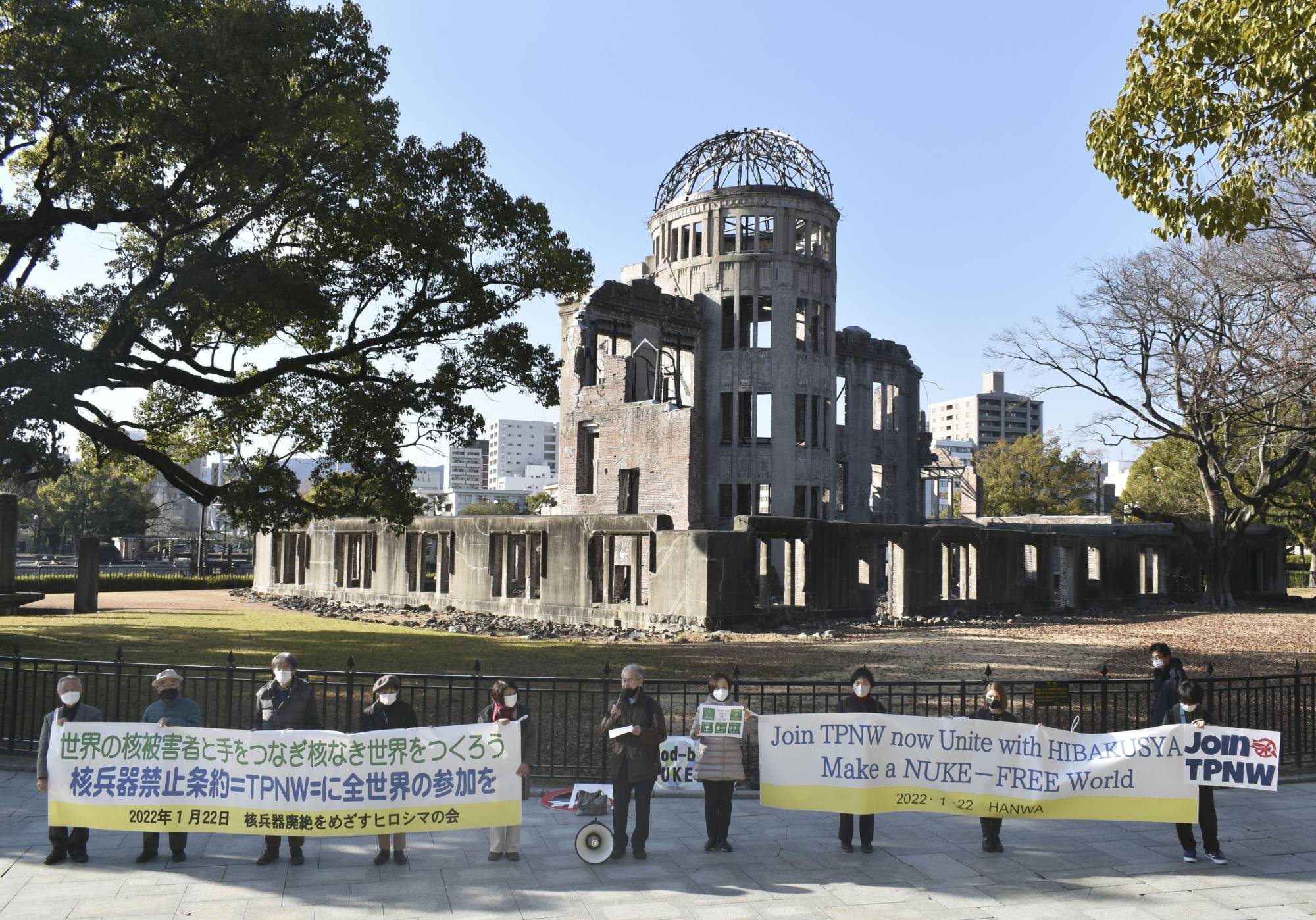 People gather in front of the Atomic Bomb Dome in Hiroshima on Jan. 22, the first anniversary of the Treaty on the Prohibition of Nuclear Weapons coming into force, calling for Japan to ratify the agreement. | KYODO