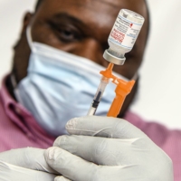 A pharmacist prepares doses of the Moderna COVID-19 vaccine in Hagerstown, Maryland, on Feb. 22.  | KENNY HOLSTON / THE NEW YORK TIMES