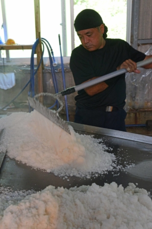 Masaru Takaesu rakes and sifts through the salt produced at his Takaesu Seienjo factory on Okinawa’s Hamahiga Island. | STEPHEN MANSFIELD 
