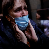 A Ukrainian woman reacts upon arriving in Madrid with a group of Spanish taxi drivers who drove to Poland to support the mass evacuation of refugees in Madrid, on Thursday. | REUTERS